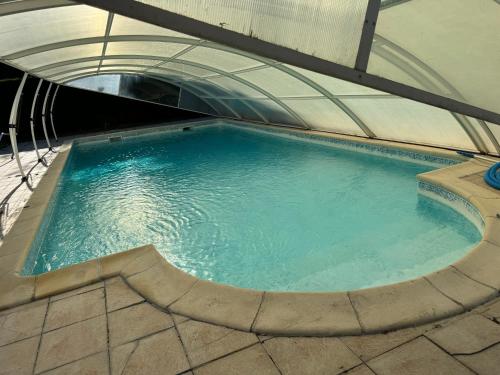 une grande piscine d'eau dans un bâtiment dans l'établissement Maison 4 personnes avec piscine, à Bourriot-Bergonce