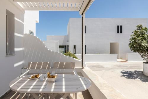 a white bench on a balcony with a table at Om Living Milos in Pollonia