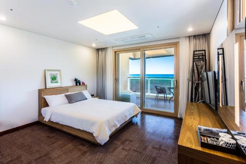 a bedroom with a bed and a view of the ocean at Sea Stay Hotel in Jeju