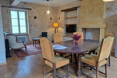 a dining room with a wooden table and chairs at Monpazier Situation idéale Lumineux Terrasse in Monpazier