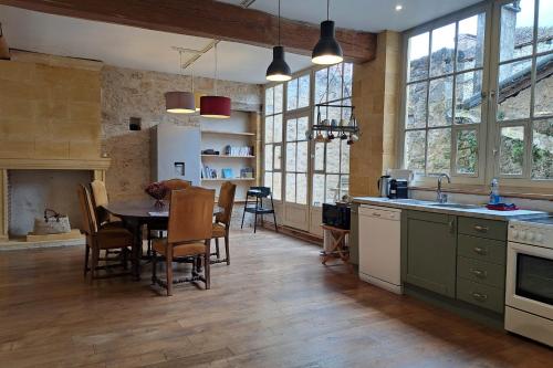 a kitchen with a table and a dining room at Monpazier Situation idéale Lumineux Terrasse in Monpazier