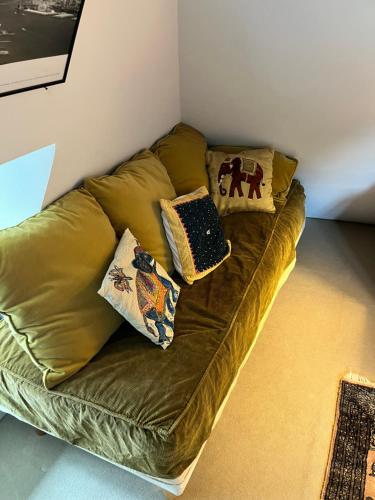 a gold couch in a room with pillows on it at Manoir La Tasserie in Saint-Philbert-des-Champs