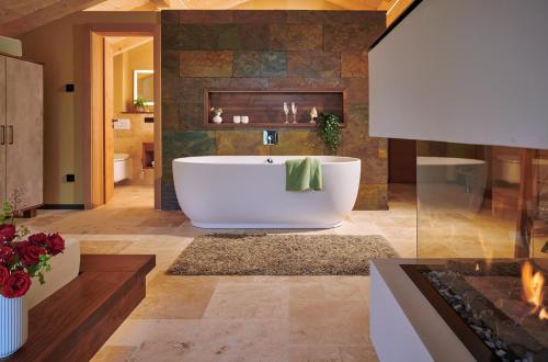 a bathroom with a large tub and a fireplace at ÜbermAlztal Chalet Alzblick Ferienwohnung in Altenmarkt an der Alz