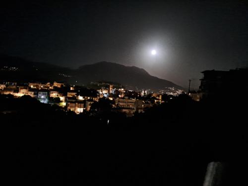 a view of a city at night with the moon at Victoria's house in Kalamata