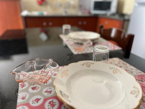 un tavolo con un piatto e dei bicchieri su un tavolo di La Palma Home a Ali Terme