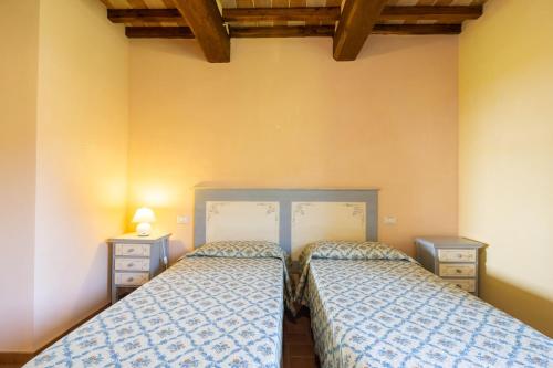 two beds sitting next to each other in a bedroom at Casale Bonavita by VacaVilla in Città di Castello