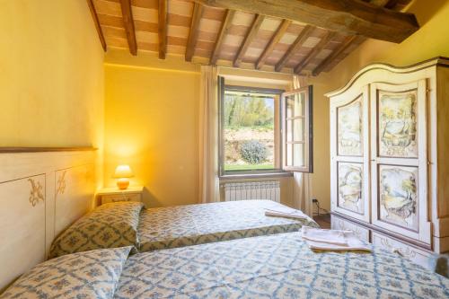 a bedroom with a bed and a window at Casale Bonavita by VacaVilla in Città di Castello