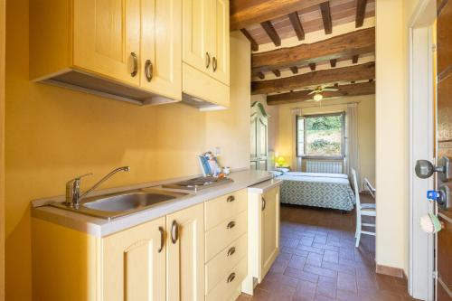 a kitchen with white cabinets and a sink and a window at Casale Bonavita by VacaVilla in Città di Castello