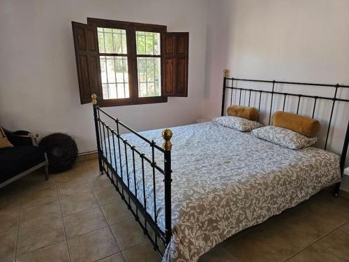 a bedroom with a bed in a room with a window at Villa Finca el Carril in Vélez de Benaudalla