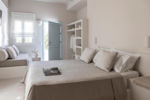 a white bedroom with a bed with a tray on it at Om Living Milos in Pollonia