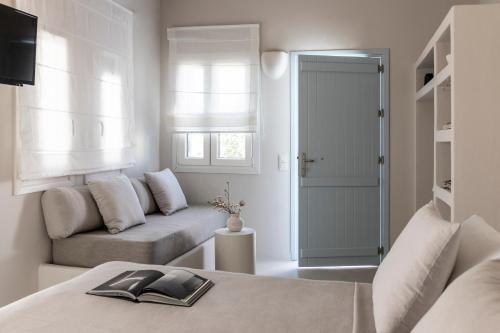a white living room with a couch and a window at Om Living Milos in Pollonia