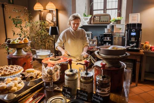 a man standing in a kitchen preparing food at Al Castello Resort in Sillavengo
