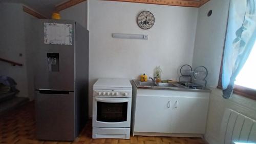 La cuisine est équipée d'une cuisinière, d'un évier et d'un réfrigérateur. dans l'établissement Maison de campagne à Bouisse, à Bouisse