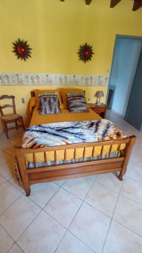 une chambre avec un lit en bois dans une pièce dans l'établissement Maison de campagne à Bouisse, à Bouisse