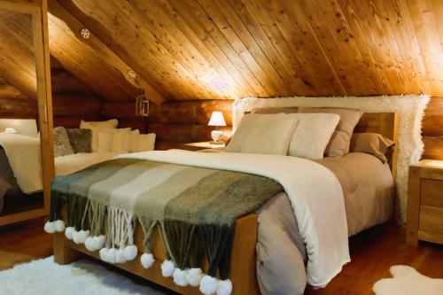 - une chambre avec un grand lit dans une cabine dans l'établissement Chalet des lacs, à Saint-Hilaire-les-Courbes