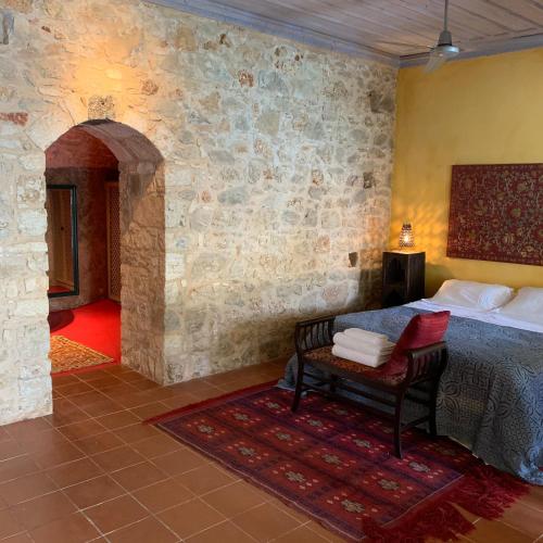 a bedroom with a bed and a chair in a room at Mediterraneo Hotel in Meyisti