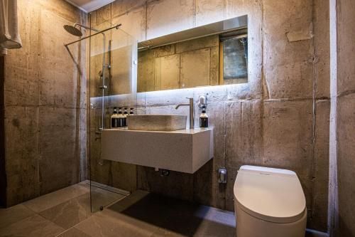 un baño con lavabo e inodoro en Jeju NuevePoolvilla Aewol, en Jeju