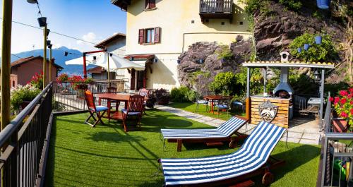 a patio with chairs and a fireplace with a table at La Casa sulla Roccia in Pisogne