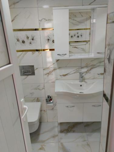 a white bathroom with a sink and a toilet at Atlas Pansıyon in Antalya
