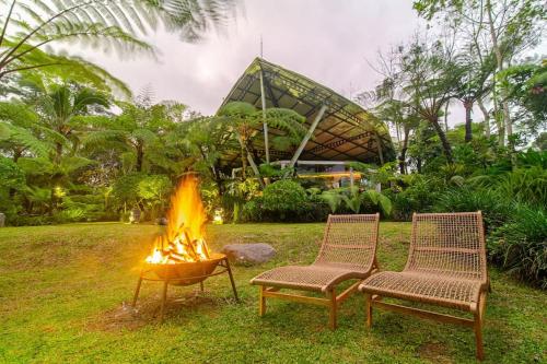 two chairs and a fire pit in a yard at Castle in the sky mountain bliss, Kintamani area in Plaga