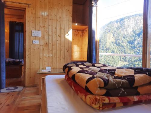 a bed in a room with a large window at THE GROOVE GARDEN DHANOLTi in Dhanaulti