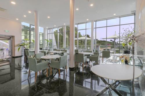 a dining room with tables and chairs and windows at Cristallo Park Hotel in Portovenere