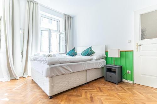 a white bedroom with a bed and a window at Convenient 3-BR Shared Apt, 15 Min to Landstraße Hub in Vienna