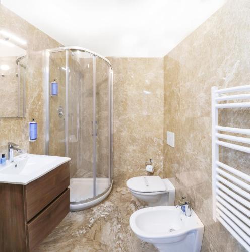 a bathroom with two sinks and a shower and a toilet at Cristallo Park Hotel in Portovenere