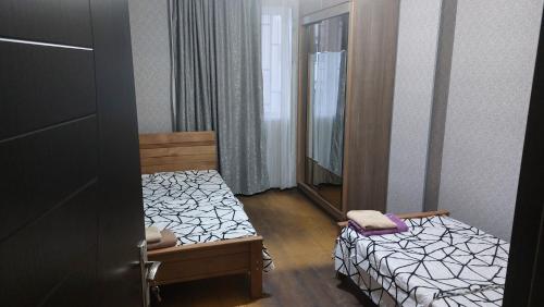 Una pequeña habitación con una cama y un espejo. en Tukhudo, en Tiflis