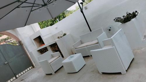 a group of white chairs and an umbrella at Suite Da Ninna 1 in Allai
