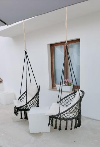 two chairs hanging from a wall with a window at Suite Da Ninna 1 in Allai