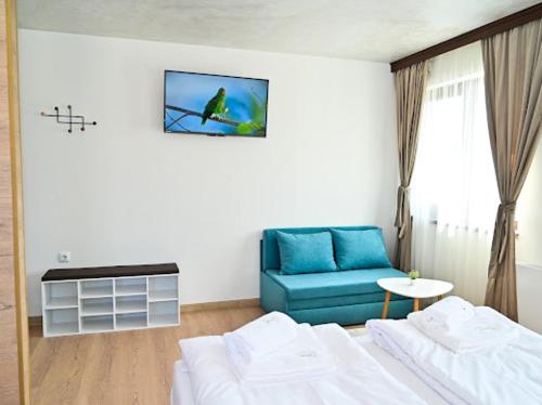 a living room with a couch and a blue chair at КЪЩА ЗА ГОСТИ ГРОШЪ in Dobrinishte