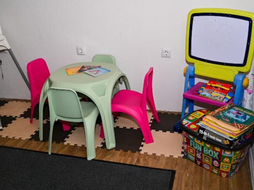 a toy room with a table and chairs and a table and chairs at КЪЩА ЗА ГОСТИ ГРОШЪ in Dobrinishte