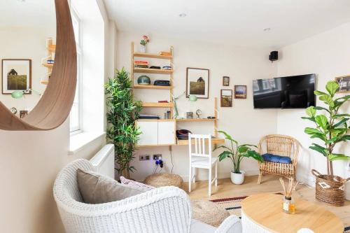 a living room with white furniture and plants at Large Luxury Studio in Heart of Richmond in Richmond