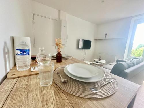 - une table avec des assiettes et des verres au-dessus du salon dans l'établissement L'Alpha, Moderne et lumineux, à Limoges