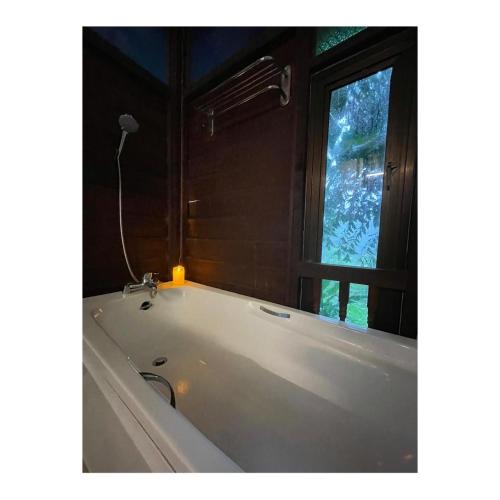 a white bath tub in a bathroom with a window at Villa Sri Kampung in Kuah