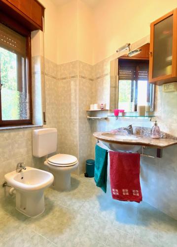 a bathroom with a toilet and a sink at Villa Cuten in Calco