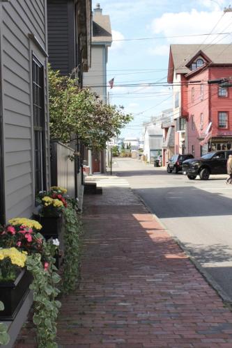 a brick sidewalk next to a house with flowers at Beautifully Renovated 2 Bed 2 Bath Private Home in Newport