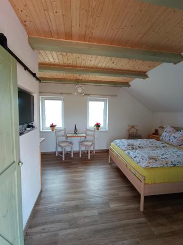 Un dormitorio con una cama y una mesa y sillas. en Vavřinec, en Břeclav
