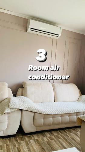 a room with a couch and a sign that reads room at Apartment Mari in Kutaisi