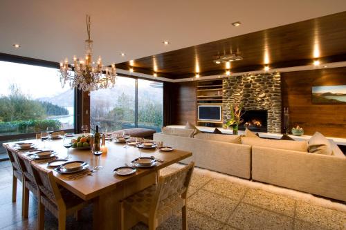 a dining room with a long table and a fireplace at Forty Two by Amazing Accom in Queenstown