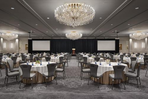 ミルウォーキーにあるThe Pfister Hotelのテーブルと椅子とシャンデリアのある会議室
