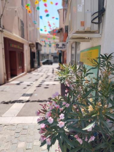 an empty street with flowers on the side of a building at Appartement EMMA Quartier historique à 400m de la mer in Saint-Raphaël