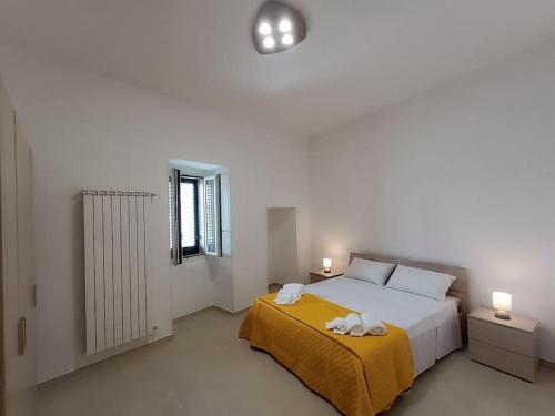 a white bedroom with a bed and a window at vacanza in Salento, La Terrazza in Surano