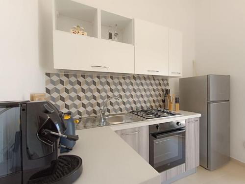 a kitchen with a sink and a refrigerator at vacanza in Salento, La Terrazza in Surano