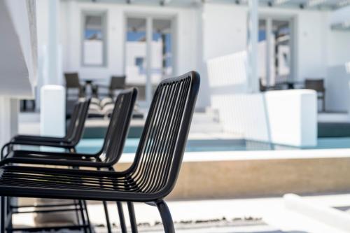 three black chairs sitting in front of a pool at Quartano Suites by Heliessa, Adults Only in Naousa