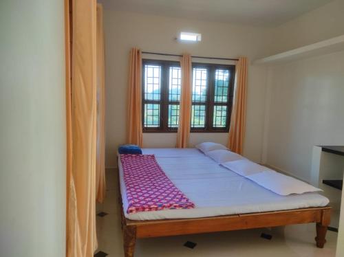 a bed in a room with a window at Chikkus Misty Coorg homestay in Kushālnagar