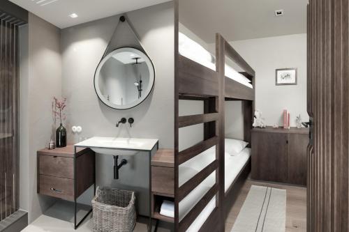 a bathroom with a bunk bed with a sink and a mirror at Hotel Rigele Royal Superior in Obertauern