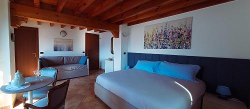 a bedroom with a bed and a table and a couch at La Casa sulla Roccia in Pisogne