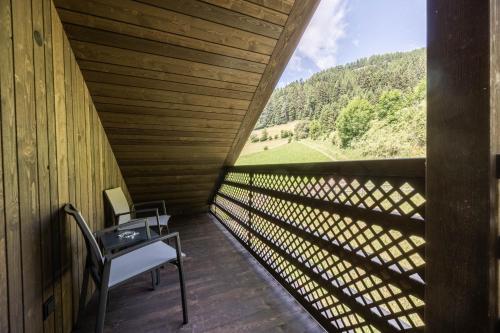 a room with a table and a chair on a balcony at Hotel Rommisa in Perca